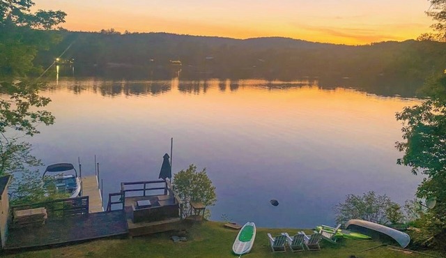 Lakefront home near ski resorts with water view, dock, deck, fireplaces, & W/D in Castleton